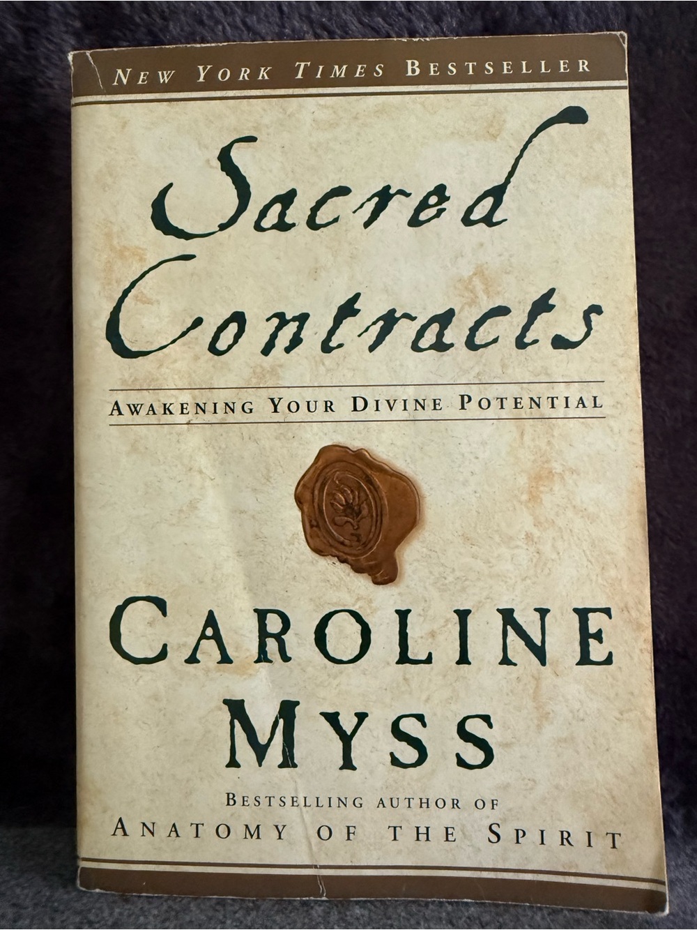 Self Help Book: Sacred Contracts by Caroline Myss - Cream Cover with Green Text